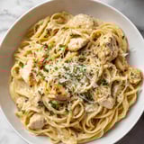 White bowl with pasta and chicken.
