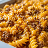 Pasta z kiełbasą i sera w misce.